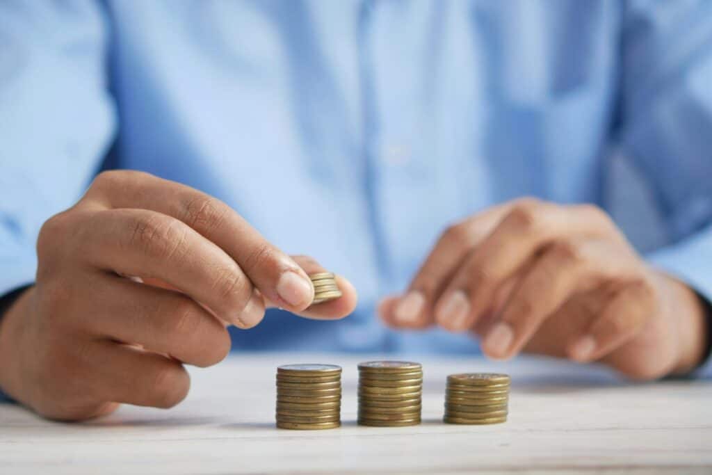 A man is counting coins on a table