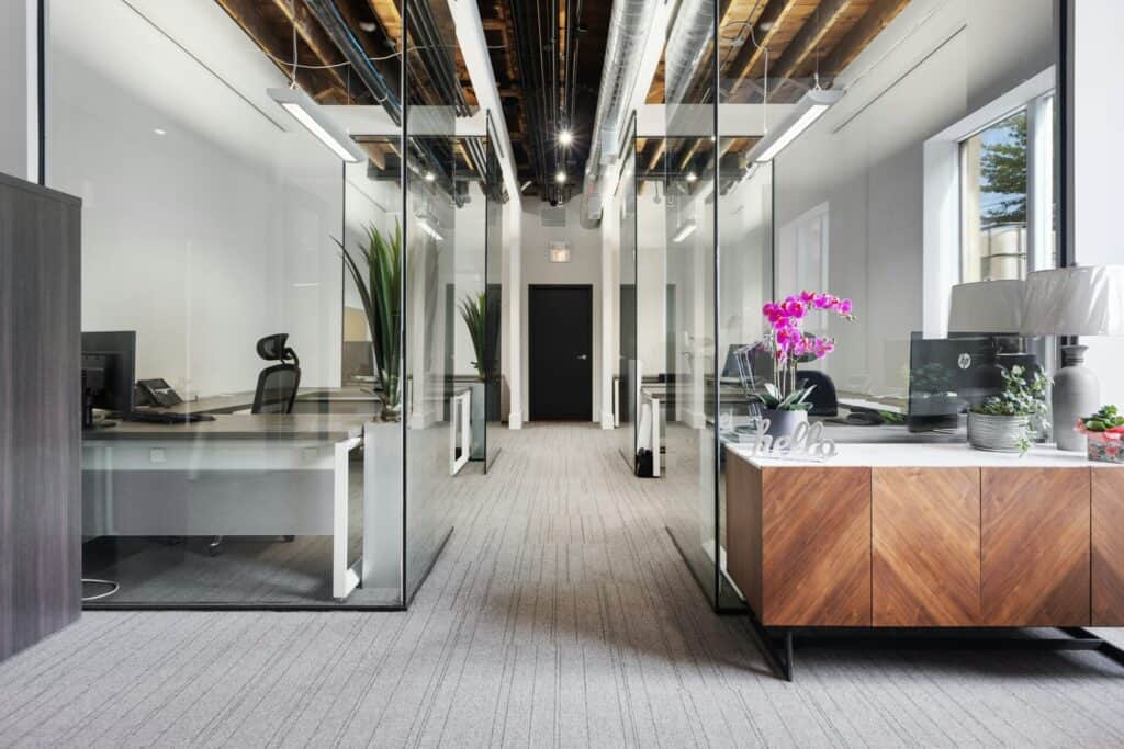 An office with glass walls and wooden floors